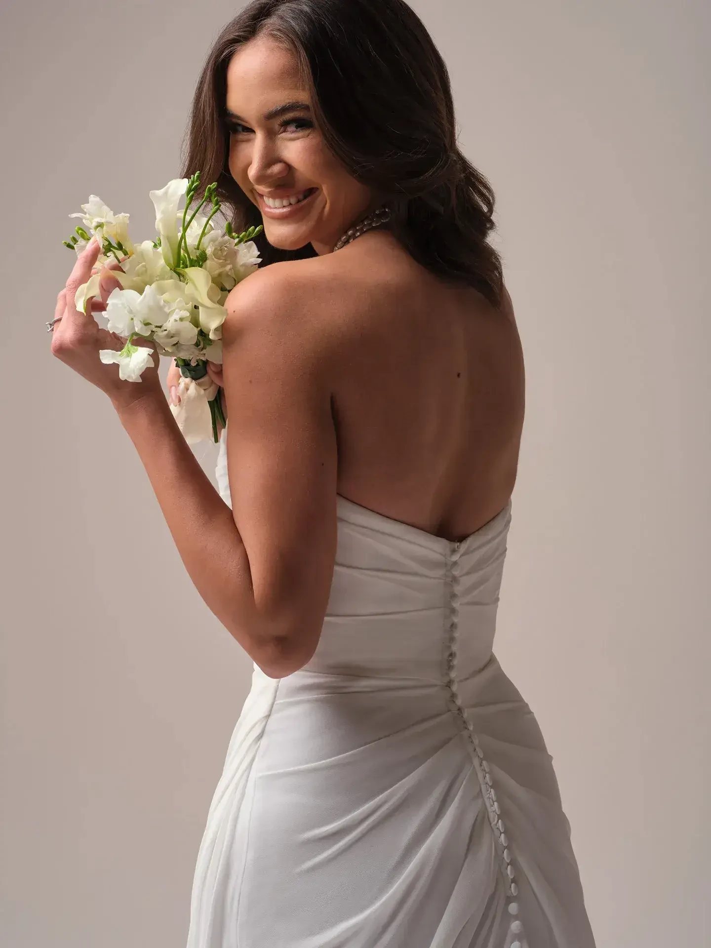 model is wearing a strapless fit and flare wedding dress