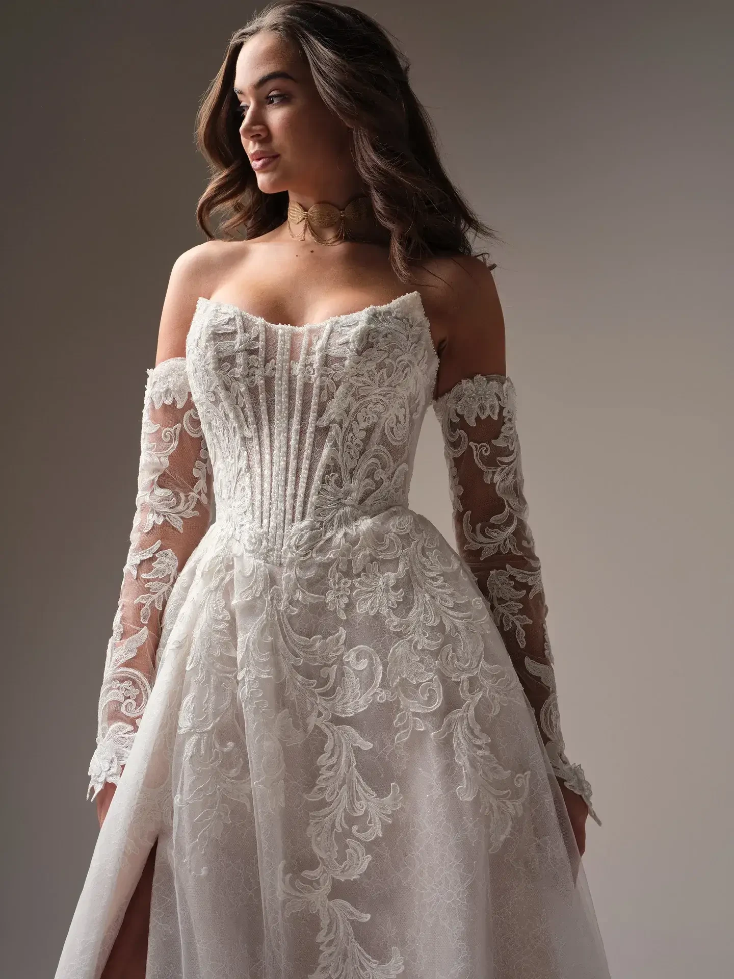 Model is wearing a soft satin sheath dress with asymmetrical sweetheart neckline, unlined bodice, and Chantilly lace with glitter tulle overlay.
