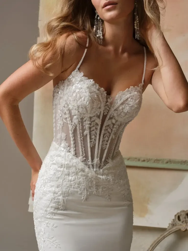 model is wearing a spaghetti strap lace wedding gown