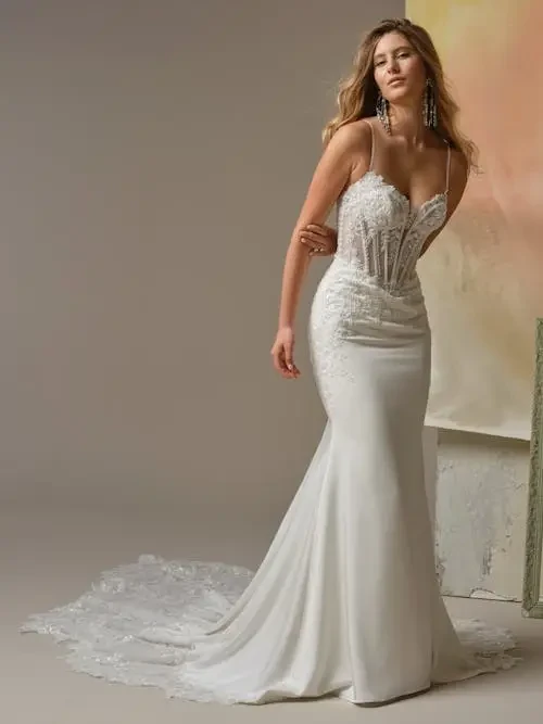 model is wearing a spaghetti strap lace wedding gown