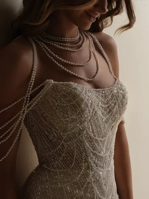 model is wearing a pearl strapless wedding gown