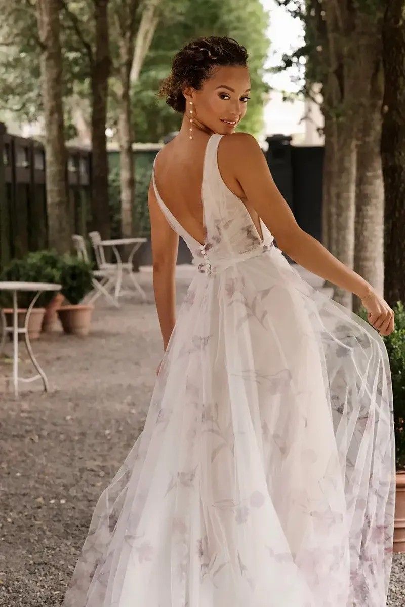 Model is wearing an a-line wedding gown with purple pastel floral printed tulle 