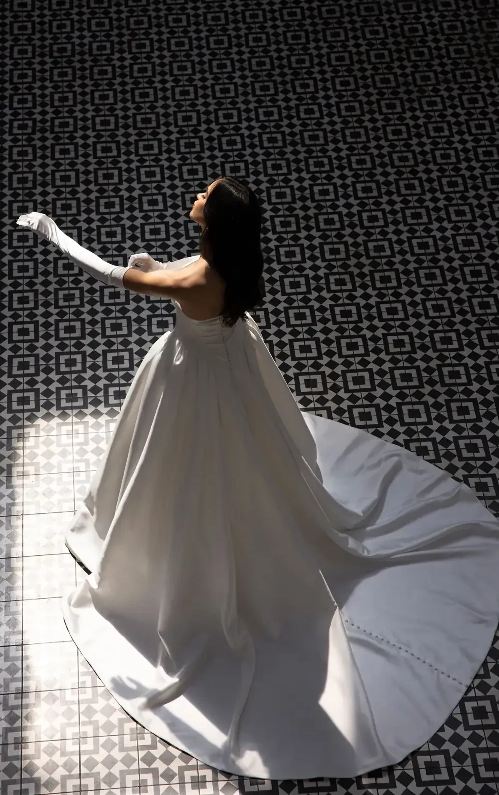 model is wearing a strapless bridal gown with long gloves