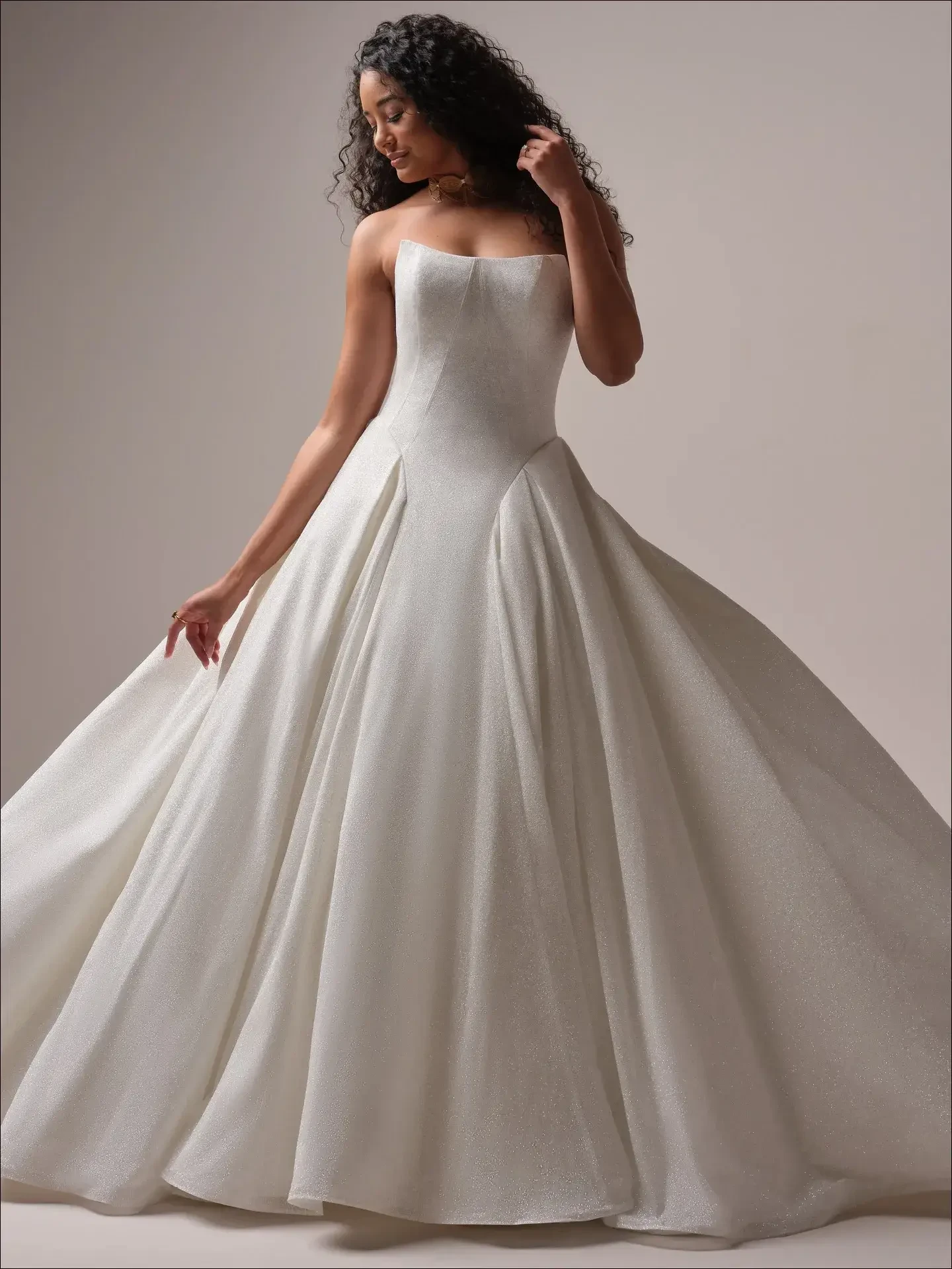  Model is wearing a voluminous sparkly regal ballgown wedding dress