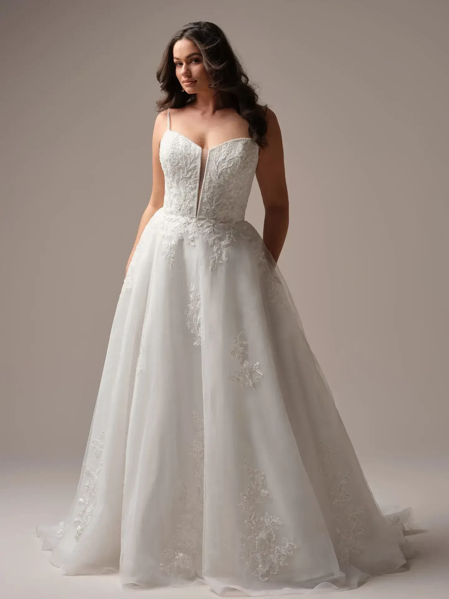 Model is wearing a structured floral plunge lace A-line wedding gown